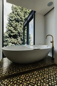 Modern bathroom with a minimalist design, featuring a large bathtub and natural light.