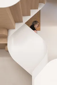 A minimalist interior design featuring a white acrylic staircase.