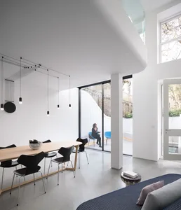 Contemporary minimalist dining room featuring concrete and glass materials.