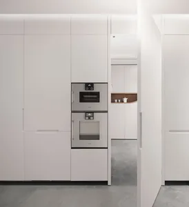 Modern kitchen with white cabinets and white appliances.