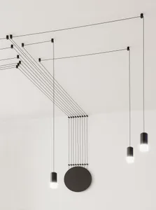 A modern lighting installation featuring a black cable structure and cylindrical light fixtures.