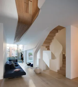 A modern residential interior featuring concrete stairs, wooden elements, and glass windows.