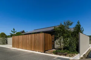 A modern residential exterior featuring wooden slats and concrete walls.