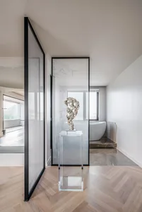 Minimalist bathroom with glass walls, porcelain floor, and marble accents.