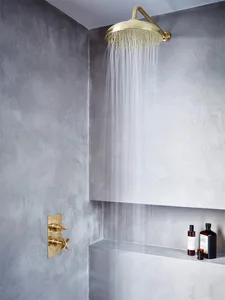 Modern bathroom featuring a shower with a concrete wall and brass fixtures.