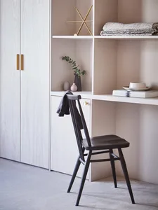 A modern home office featuring wooden furniture, including a chair, shelving unit, and cabinet.