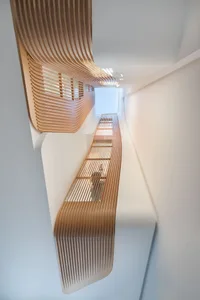 Interior view of a modern staircase featuring wooden slats.