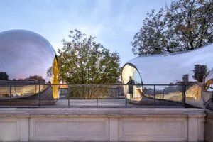 A modern, metallic exterior space with a reflective, curved metal structure.
