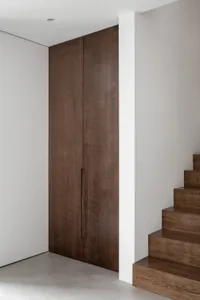 Modern minimalist interior with wooden cabinetry and white walls.