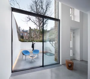A modern residential interior featuring concrete and glass materials.