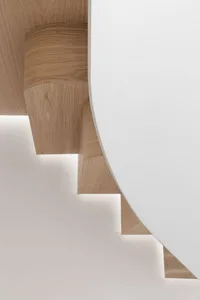 A modern staircase made of white oak with a curved design.