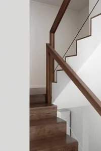 A modern staircase with wooden steps and a glass railing.