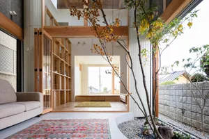 A modern living room with wooden elements and a colorful rug.