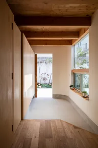 Modern minimalist entryway featuring a concrete floor, wood cabinetry, and large window