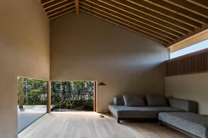 A minimalist living room featuring concrete flooring and wood slat wall.