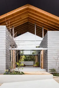 Modern minimalist residential entry veranda with green armchair and white bench.
