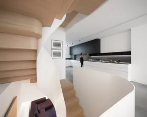 Contemporary kitchen featuring white cabinetry and wooden stairs.
