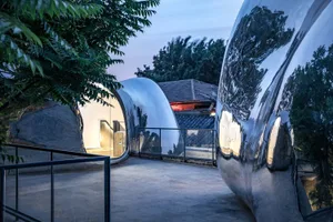 Modernist art installation featuring metallic reflective spheres in an urban environment.