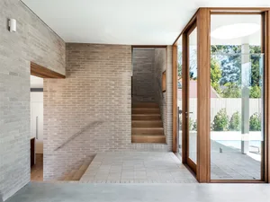 Modern industrial lobby featuring exposed brick walls, concrete flooring, and large glass windows