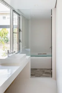 Minimalist bathroom featuring a glass shower enclosure and porcelain fixtures.