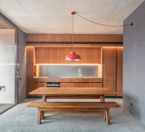 Modern industrial kitchen with wood cabinets and pendant light fixture.