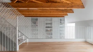 Industrial-style staircase with metal railings and wooden ceiling beams.