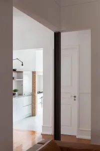 A minimalist kitchen with white flooring, showcasing sleek white cabinetry and modern design elements.