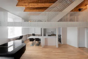 Modern apartment with white walls and wooden floors, featuring a kitchen and dining area.