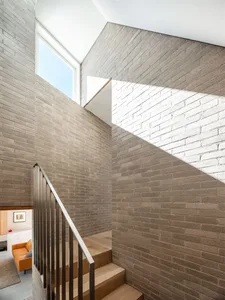 Modern stairs with brick walls and wooden steps.