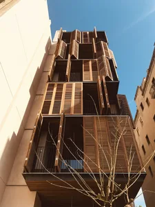 A modern building facade featuring wooden shutters.