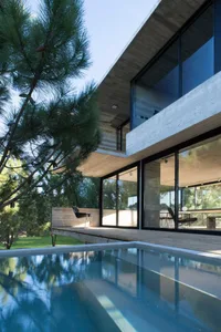 A modern house exterior featuring concrete materials with large glass windows.