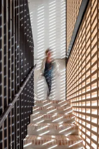 A modern interior design featuring brick and concrete walls with metal railings.