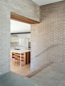 Modern kitchen with wood floor and white countertops.