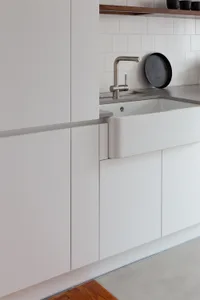 A minimalist kitchen with white cabinetry.