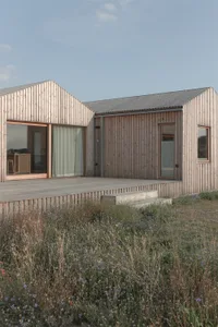 Modern vacation home exterior with timber siding and large windows.