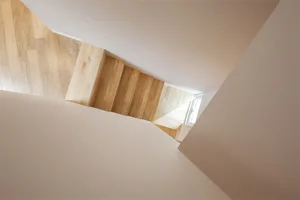 A modern staircase made of light-colored wood.