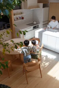 A minimalist residential kitchen featuring ceramic tiles and wooden furniture.