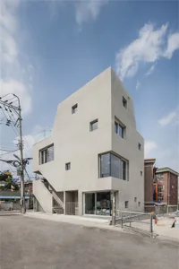 Modern building with smooth concrete exterior and large glass windows.