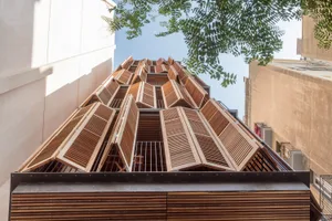 A modern building with wooden exterior architecture seen from below.
