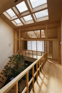 Modern hallway with glass skylights and wooden flooring and railings.
