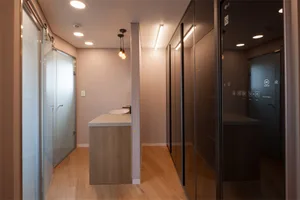 Modern interior space with a glass door and wooden flooring.