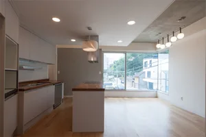 Contemporary living room featuring wooden flooring and a large glass window.
