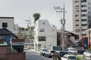A photo of a modern urban architectural space with buildings, cars, and electrical wires.