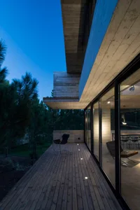 Modern concrete terrace with wooden flooring and furniture, featuring a sleek, minimalist design.