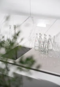 A minimalist residential kitchen featuring glass and marble materials.