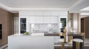 Modern kitchen interior with marble countertops and white cabinets.