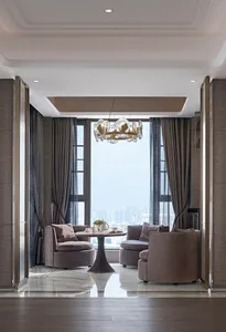 A modern living room featuring fabric furniture, a glass window, and metal accents.