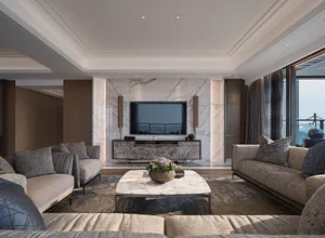 Modern living room with marble walls, suede sofas, and wooden accents.