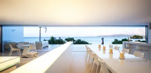 Modern minimalist vacation home featuring a sea view, glass walls, cement floor, and tropical plants.