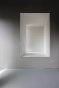 Modern bathroom with minimalist design, featuring concrete walls and floor.